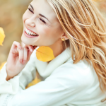 Woman Smiling Hold A Yellow Leaf