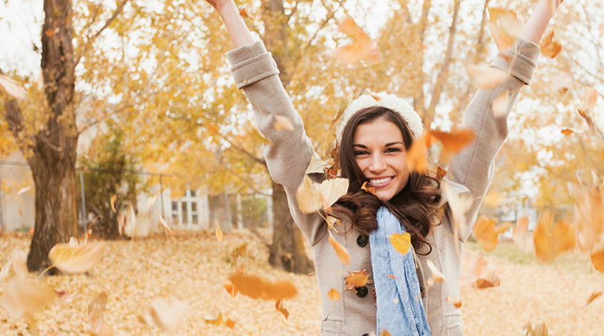 Woman Throwing Fall Leaves in Air
