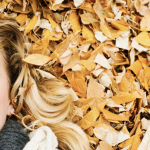 Woman Laying on Fall Leaves